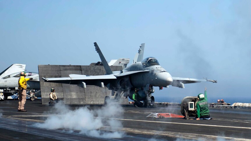 A FA18 Hornet prepares to take off from deck of US destroyer in Mediterranean Sea