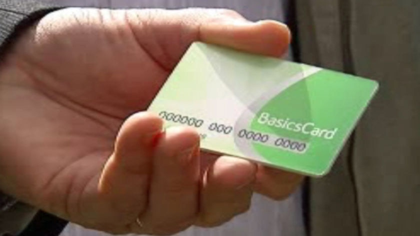 Hand holding a Basics Card used for quarantining welfare payments.