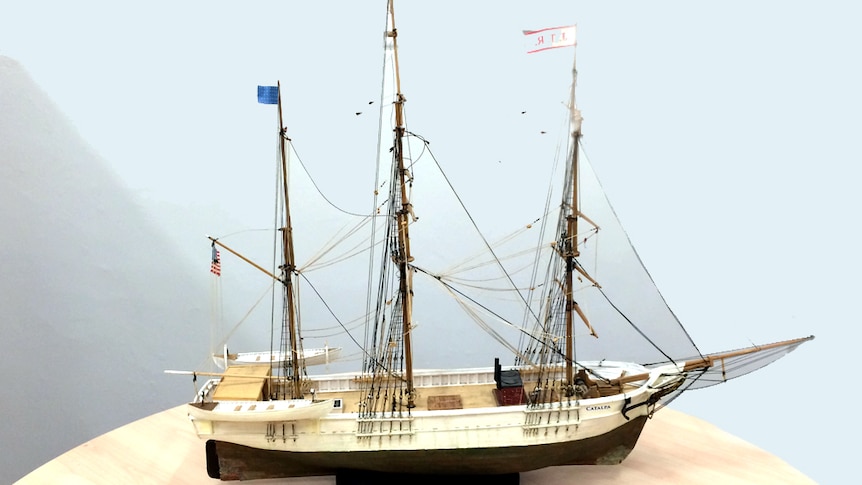 A model three masted ship resting on a desk
