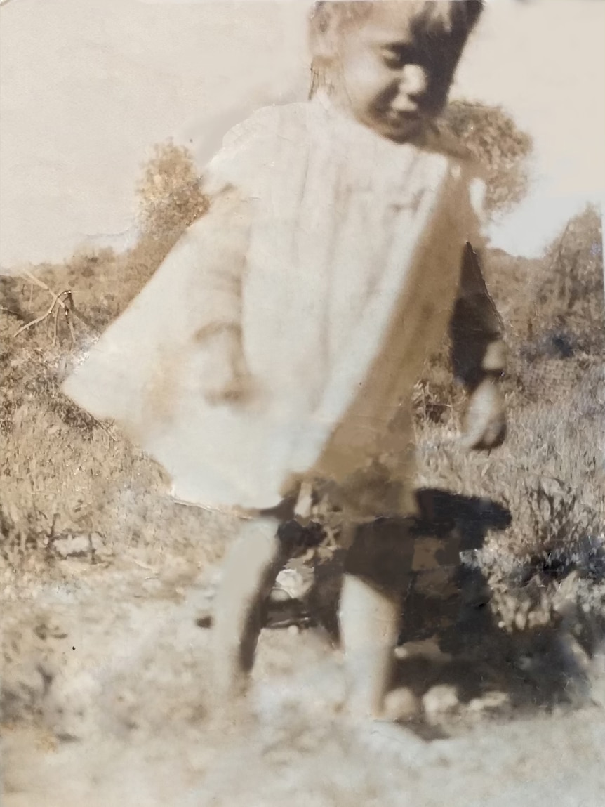 A young Indigenous girl in a flowing dress.