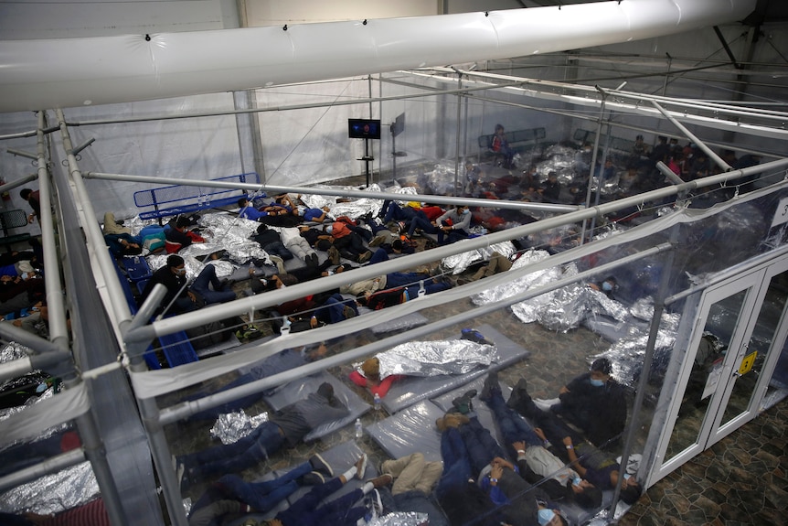 Children sleep close together in an immigration detention centre