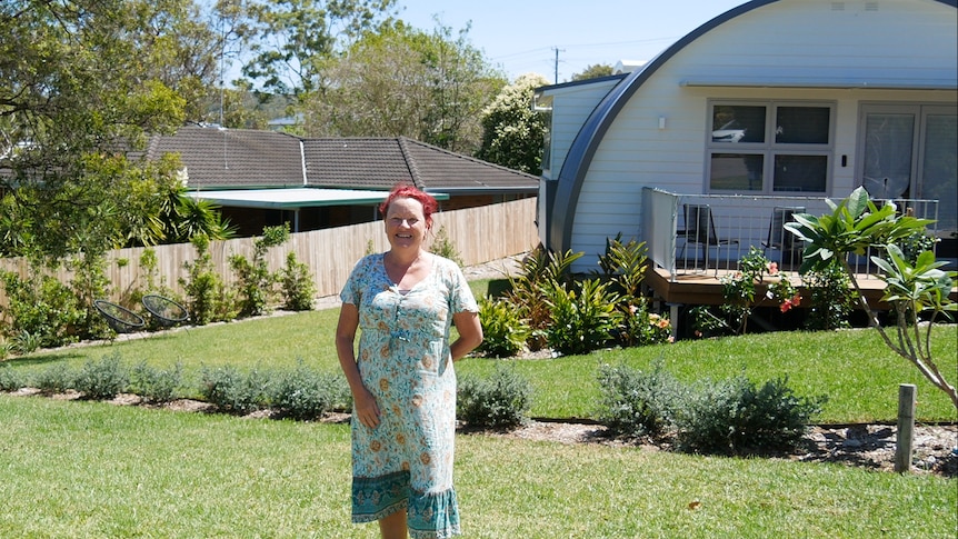 Darlene Callen standing out the front of a renovated Nissen hut. 