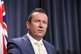 A head and shoulders shot of Mark McGowan speaking during a media conference indoors.