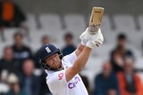 Jonny Bairstow holds his bat up in the air after playing a shot down the ground