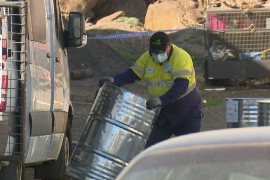 A man moves a drum containing a liquid chemical know to be used to make the drug GHB at a property in Craigieburn.