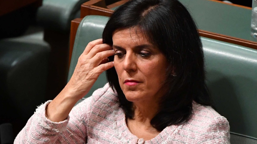 Julia Banks pushes her hair off her face