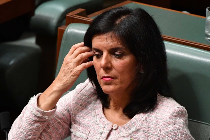 Julia Banks pushes her hair off her face