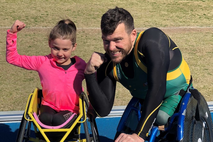 Brydi Saul and Kurt Fearnley flex their muscles while sitting in their race chairs.