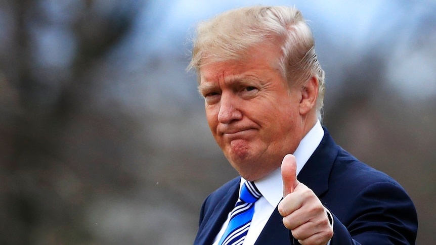 Close-up of donald trump giving thumbs-up gesture.