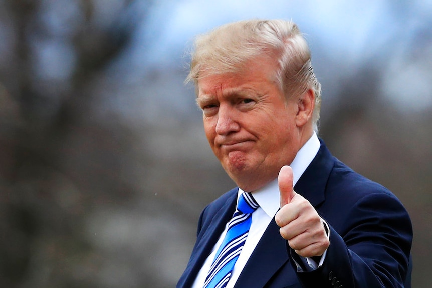 Close-up of donald trump giving thumbs-up gesture.