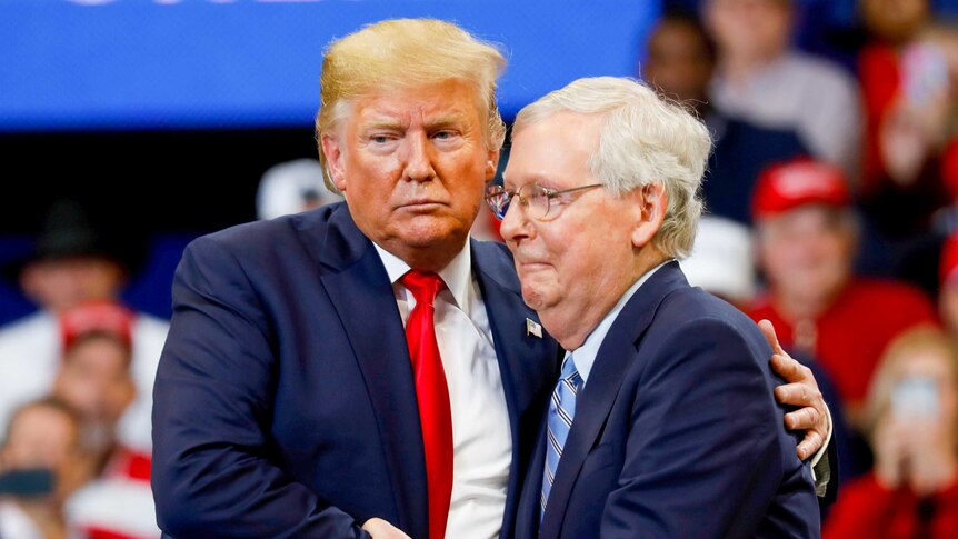 Donald Trump with his arms around Mitch McConnell at a rally