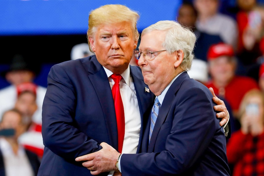 Donald Trump with his arms around Mitch McConnell at a rally