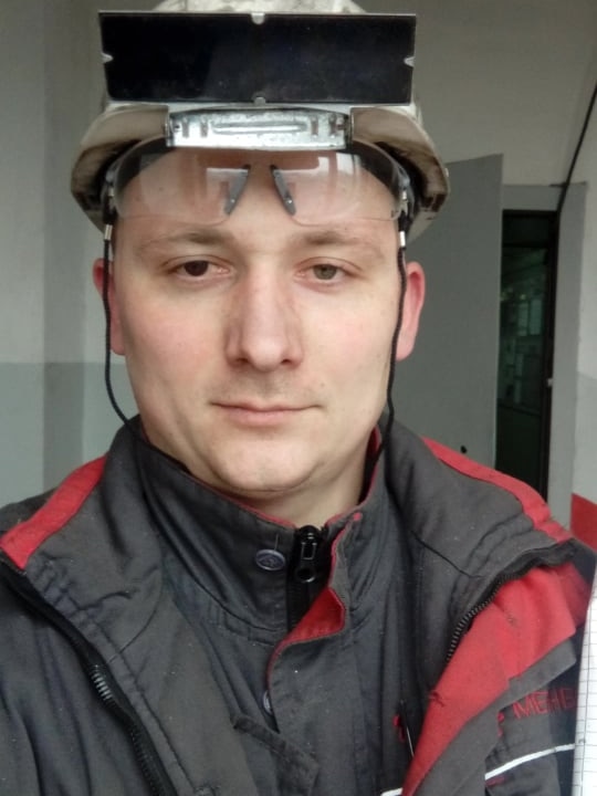 A selfie of a man with protective eyewear sitting on his head.