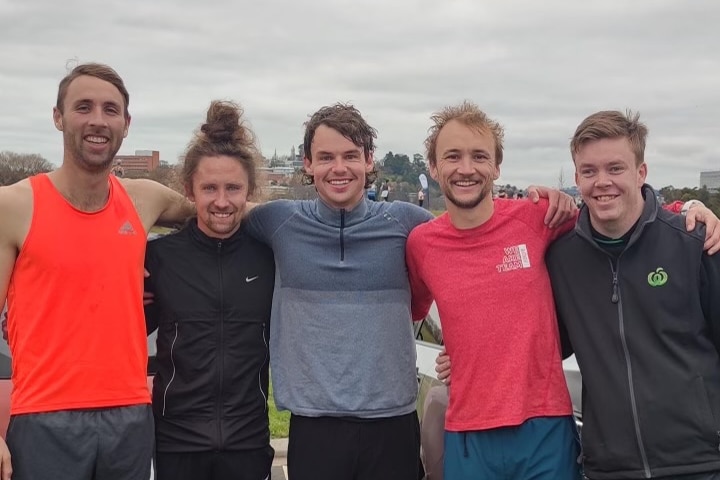 Australian Parkrun record holder James Hansen standing in the centre flanked by his course pacers after setting the record.
