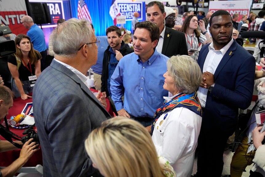 Ron DeSantis speaks with audience members during a fundraising picnic.