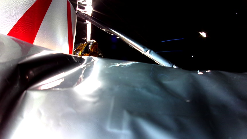 A close up of the damaged surface of a spacecraft as it floats through space.
