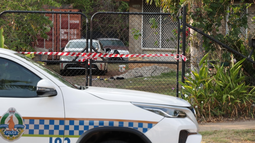 a police car in front of a house with police tape on gate