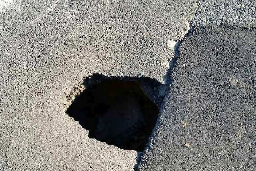 The hole, approximately 60cm deep, is in the middle of the busy road.