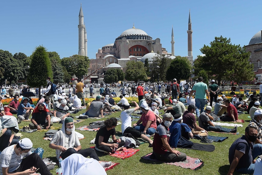 People wait on prayer mats outside Hagia Sophia in Istanbul.