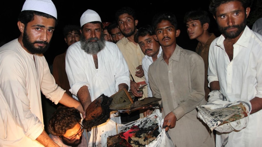 Leaders of Bharchundi shrine show burnt copies of the Koran.