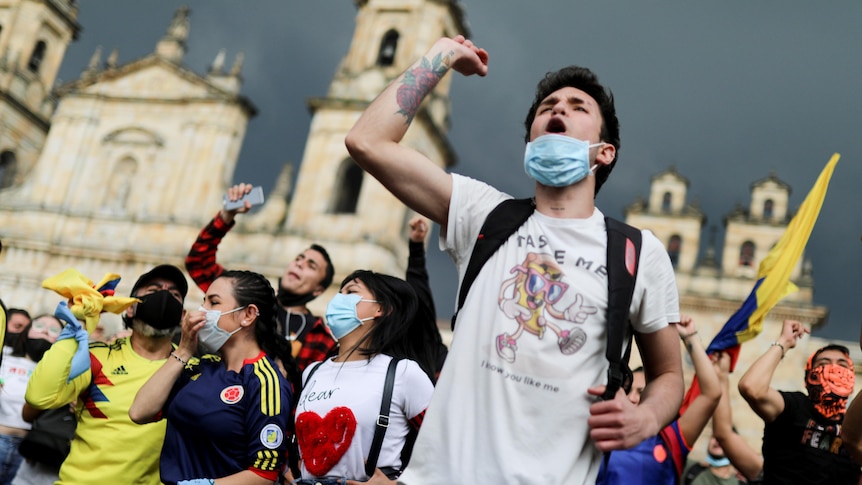 A man in a mask protests in the street.