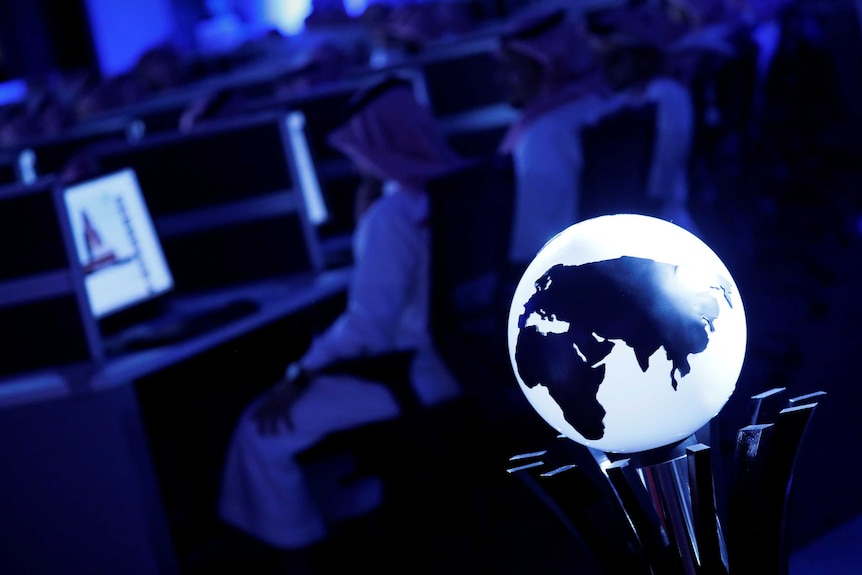 A luminescent globe of earth is positioned in the foreground as data collectors sit at screens inside the new Global Centre