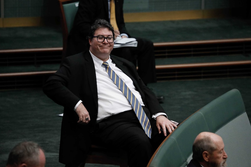 Christensen sits back in his chair, has a really long tie.