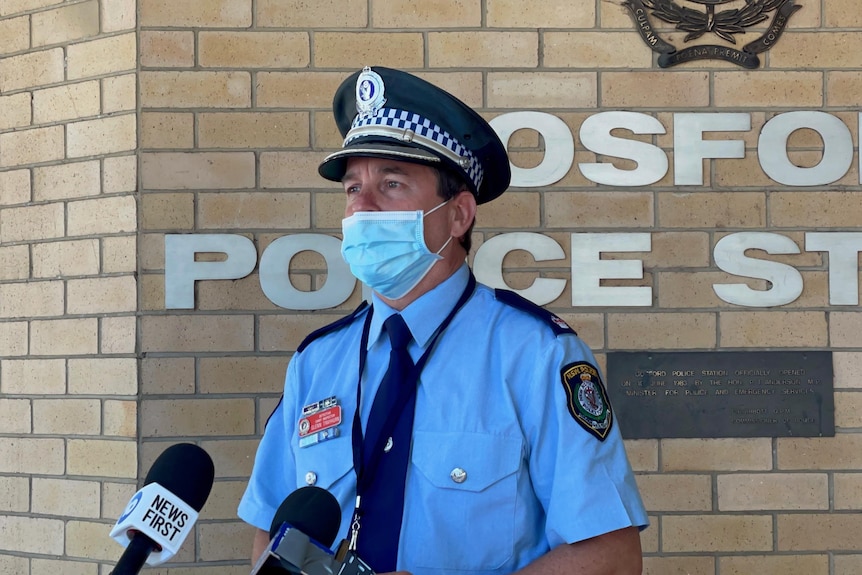 Detective Inspector Glenn Trayhurn from Brisbane Water Police, with a facemask, standing outside Gosford police station.