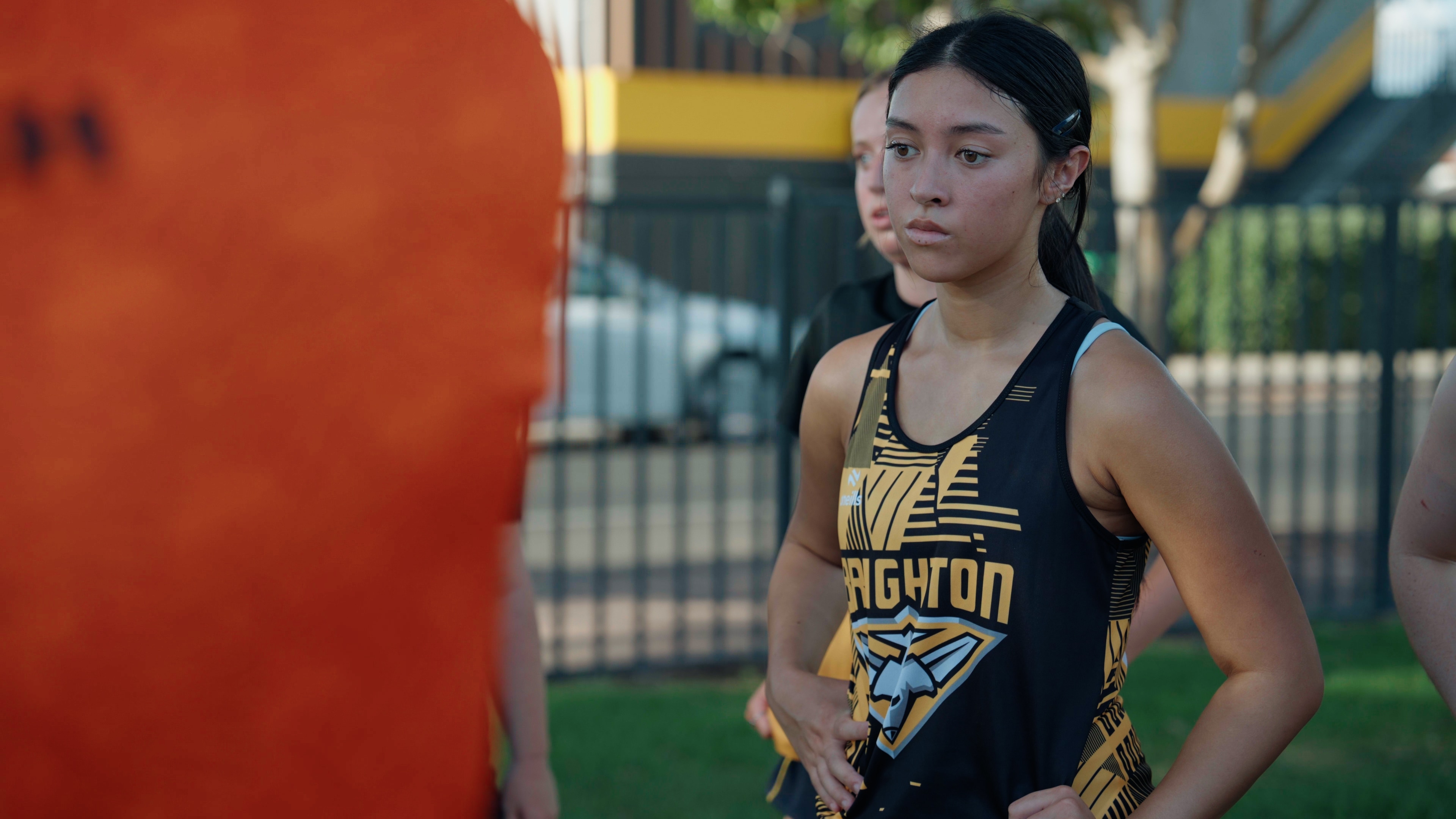 Uma jovem com uniforme de futebol.