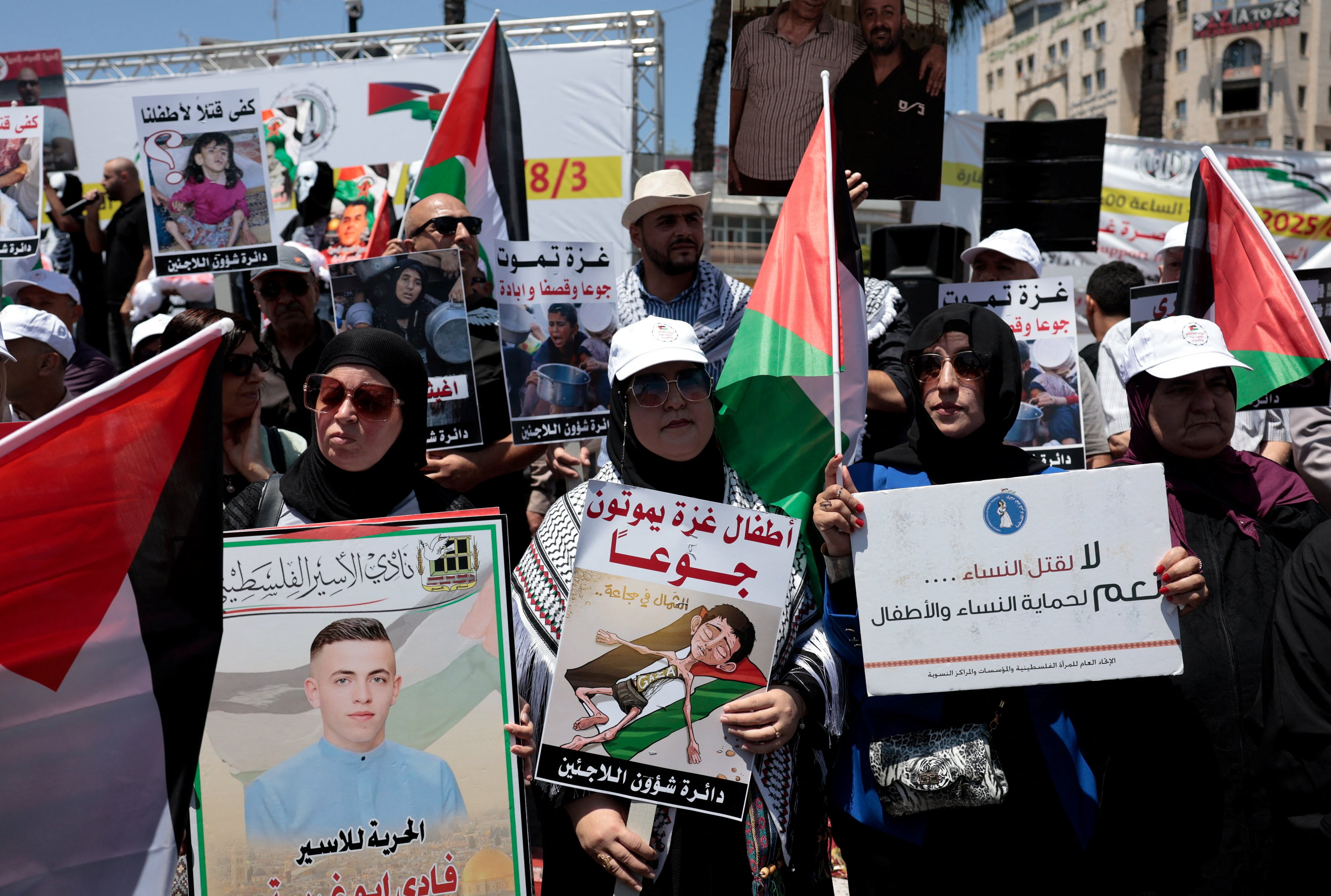 A group of protesters hold placards and signs.  