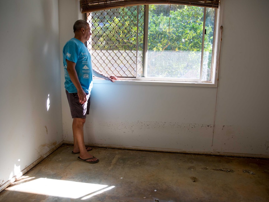 Johnny Karam in a flood-damaged bedroom