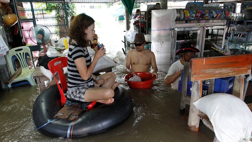 A vendor sells her wares in her flooded shop in Thailand's Ayutthaya province