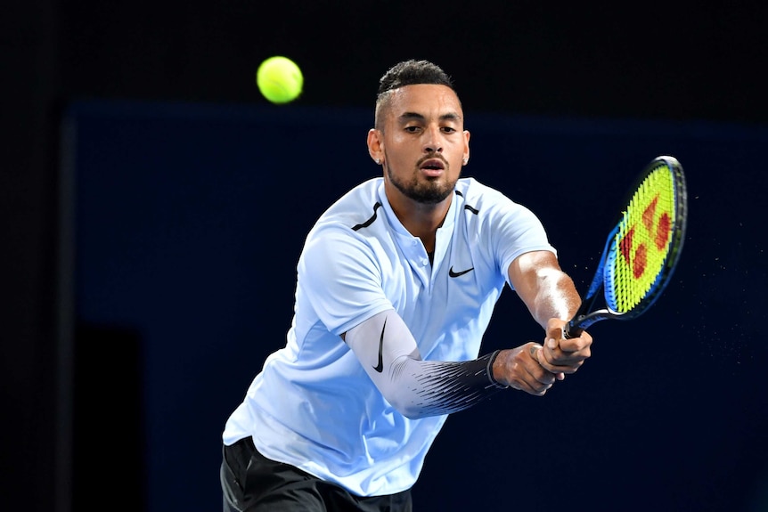 Nick Kyrgios stretches for a double-fisted backhand against Ryan Harrison in the Brisbane International final.