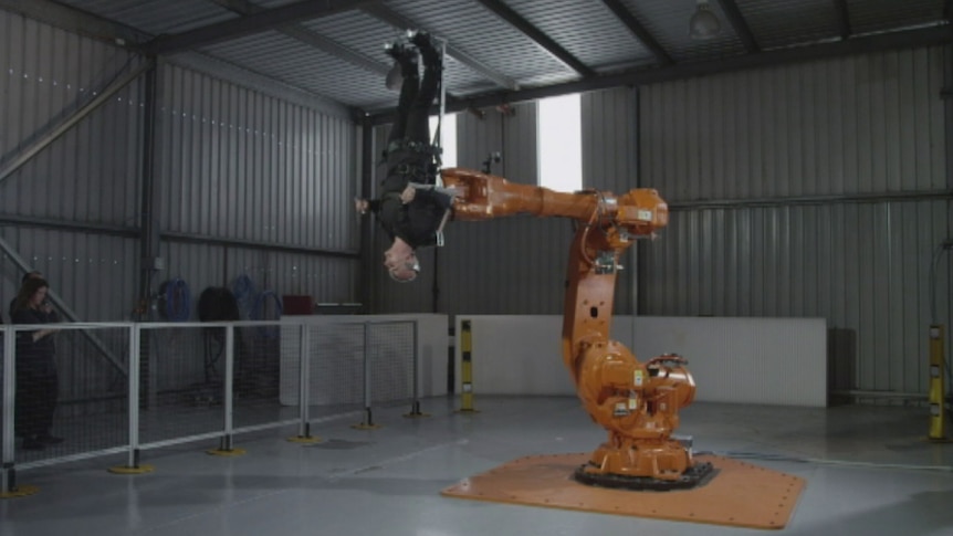 Stelarc spun around by giant robotic arm