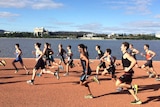 Runners set off along the shores of Lake Burley Griffin, with the Parliamentary Triangle in the background.