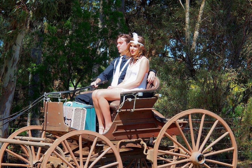 Taylor Pfeiffer in a horse-drawn buggy with male companion