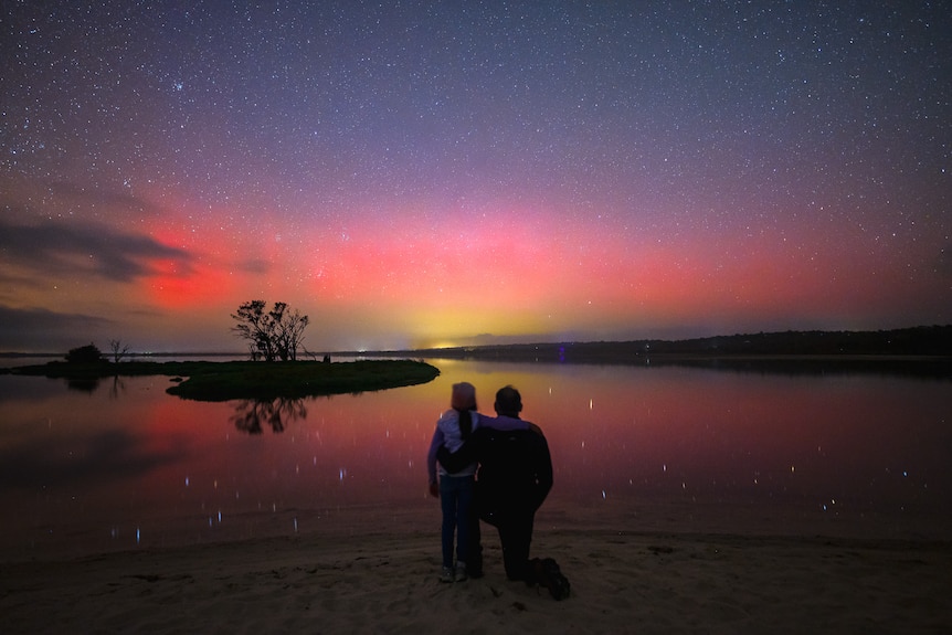 Silhouette of man and child with southern lights