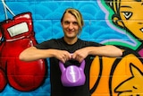 Deaf gym instructor Jarran Harris with a kettle bell