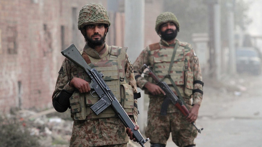 Pakistan soldiers stand guard during a patrol along a road leading to Central Jail Lahore December 20, 2014.