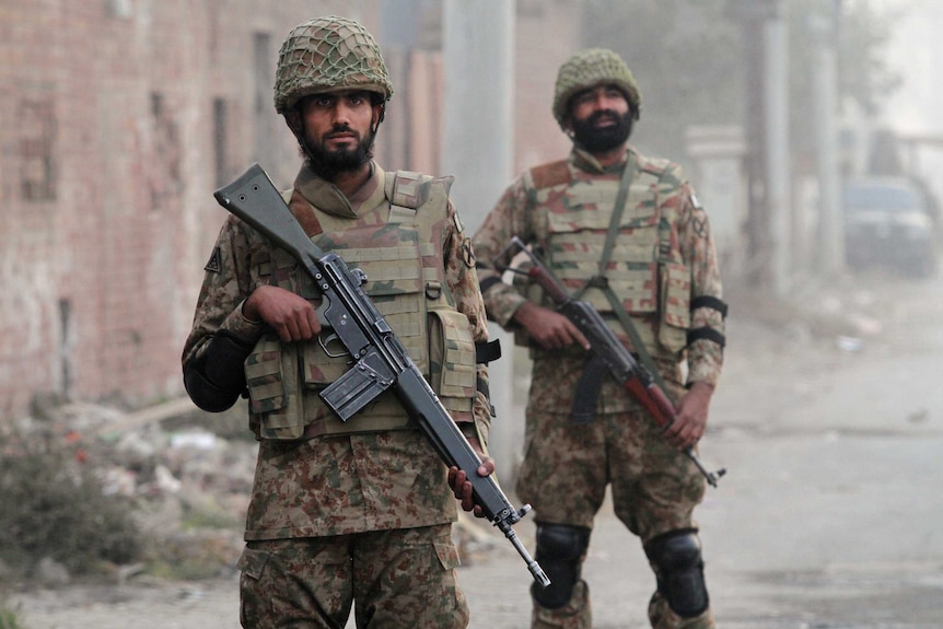 Pakistan soldiers stand guard during a patrol along a road leading to Central Jail Lahore December 20, 2014.