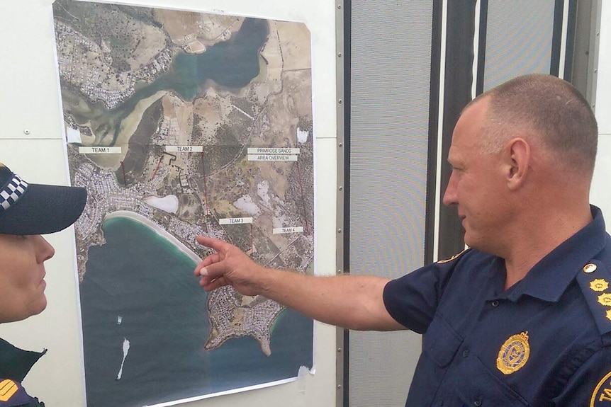 Tasmania Police Detective Inspector Steven Bourke looks at a map of Primrose Sands.