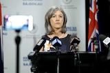 Nicola Spurrier in front of microphones at a press conference.