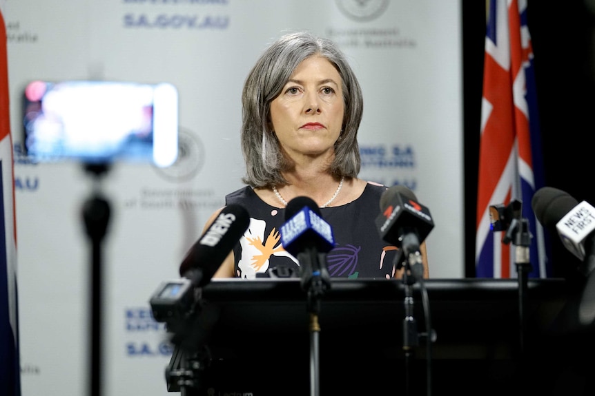 Nicola Spurrier in front of microphones at a press conference.