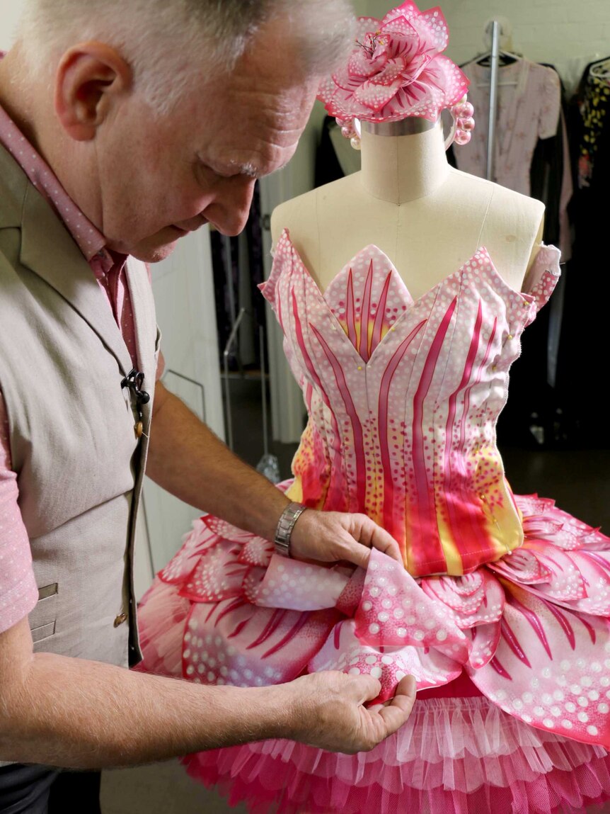 Charles Cusick Smith handles the pink petals on a pink, flower-shaped tutu.