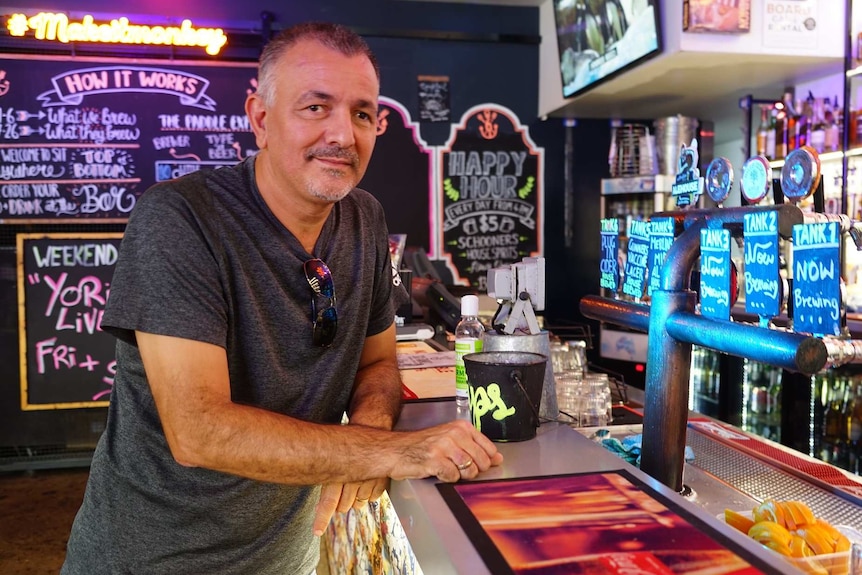 Matt D'Arrigo sits in front of a bar.