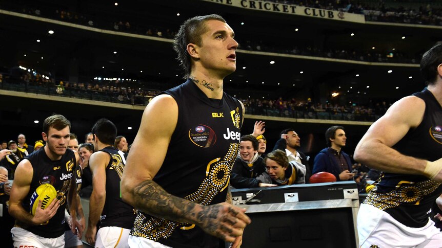 Dustin Martin and the Tigers run on to the MCG wearing Dreamtime jumper in support of Adam Goodes