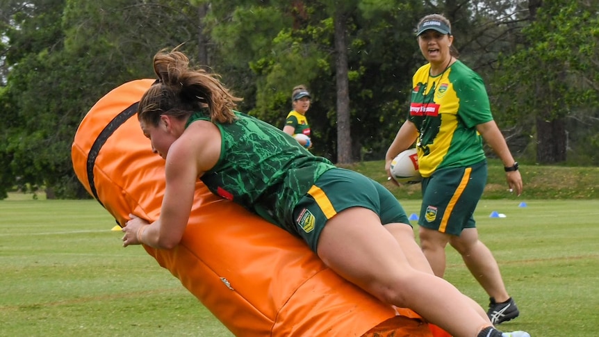 A player tackles a bag while Jess Skinner watches on.