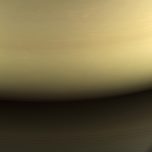 A view of clouds on approach to Saturn, with the planet's inner most rings visible.