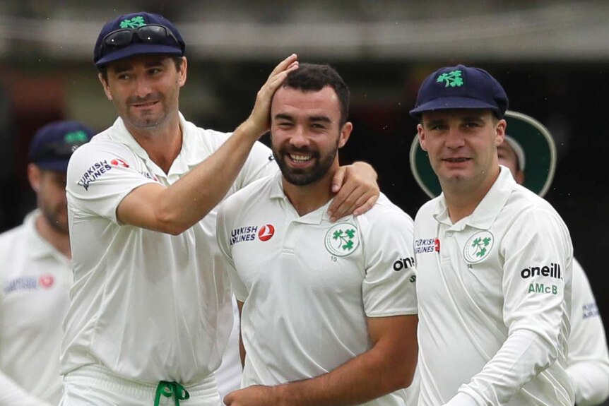 Ireland bowler Stuart Thompson is patted on the head by teammates after taking a Test wicket against England.