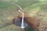 Aerial of waterfall flowing down cliffs